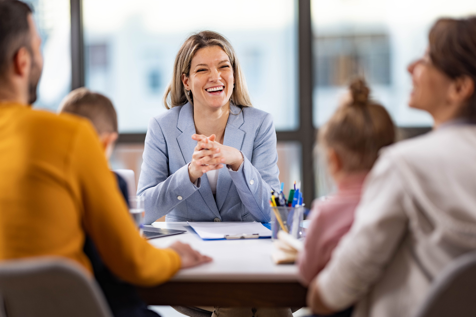 Female school principal talking to a family about children's education in the office.